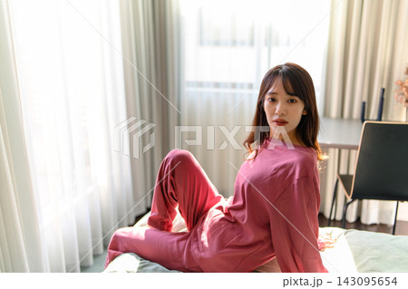 ベッドでくつろぐリラックスした表情の女性 143095654