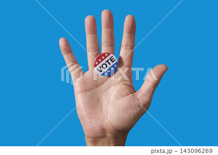 a vote badge on the open palm of a man 143096269