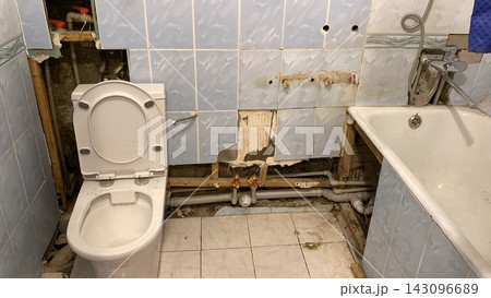 Demolished bathroom during renovation works with exposed pipes and old tiles. Horizontal shot Demolished bathroom during renovation works with exposed pipes and old tiles. Horizontal shot 143096689