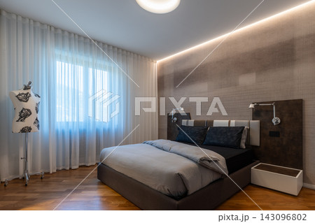 Italian designed bedroom with circular ceiling recess, upholstered bed and sheer curtains 143096802