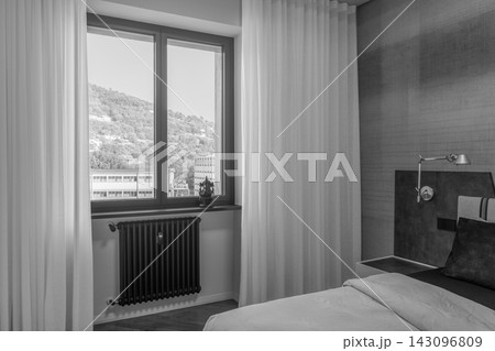 Monochrome contemporary bedroom with window, curtains and dark radiator Monochrome contemporary bedroom with window, curtains and dark radiator 143096809