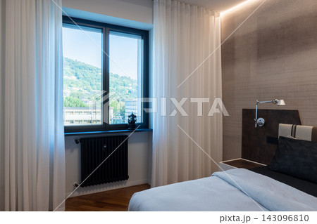 Contemporary Italian bedroom with sheer curtains and warm LED lighting Contemporary Italian bedroom with sheer curtains and warm LED lighting 143096810