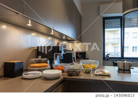 Covered cake and prepared dishes on a kitchen island for dinner at home 143096813