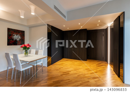 Dining table and dark mirrored hall with Iroko parquet in contemporary home Dining table and dark mirrored hall with Iroko parquet in contemporary home 143096833