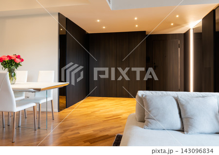 Contemporary living and dining area with Iroko parquet and dark entrance hall 143096834