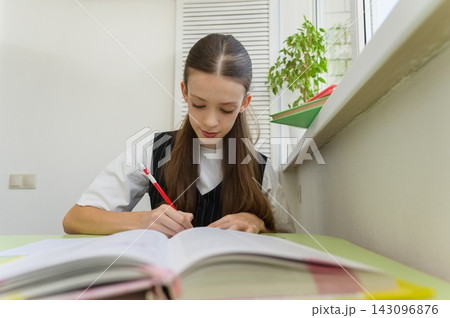 Teenage high school girl studying at a desk in her room. 143096876