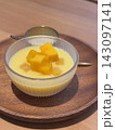 Fresh mango pudding dessert topped with mango cubes in a glass bowl 143097141