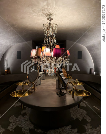 Luxurious washroom interior featuring ornate chandelier and gold sinks 143097172