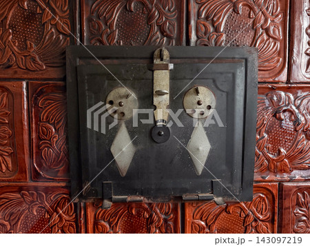 Vintage tiled stove door featuring decorative old patterns Vintage tiled stove door featuring decorative old patterns 143097219