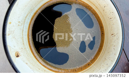 Coffee beverage in cup showing foam and liquid 143097352