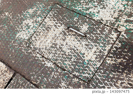 Close-up of a weathered metal manhole cover, industrial background 143097475