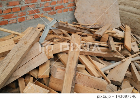 Pile of scrap wooden boards at a construction site during the day Pile of scrap wooden boards at a construction site during the day 143097546