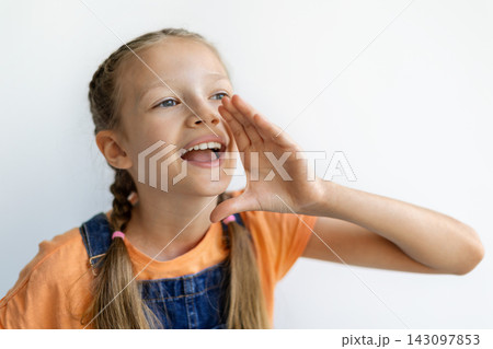 Cheerful teen girl cupping hand around mouth as if making an announcement 143097853