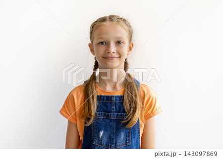 Smiling preteen girl with braided hair posing against white background at home Smiling preteen girl with braided hair posing against white background at home 143097869