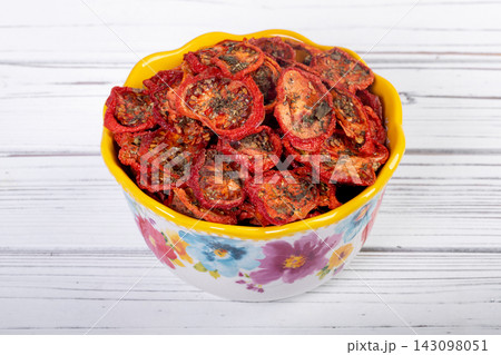Bowl with dehydrated red fragrant tomatoes with herbs and spices. Bowl with dehydrated red fragrant tomatoes with herbs and spices. 143098051