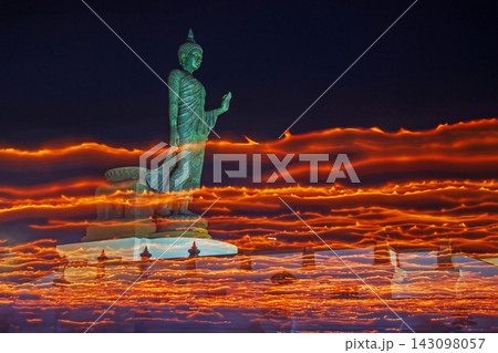 Buddha statue illuminated by flickering lights against a night sky Buddha statue illuminated by flickering lights against a night sky 143098057