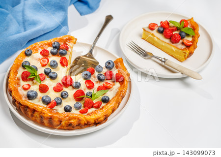Whole berry tart with missing slice on white background Whole berry tart with missing slice on white background 143099073