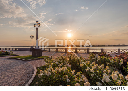 Beautiful riverside promenade with flowers at sunset Beautiful riverside promenade with flowers at sunset 143099218