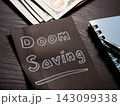 Doom saving message beside cash and note for financial uncertainty. 143099338