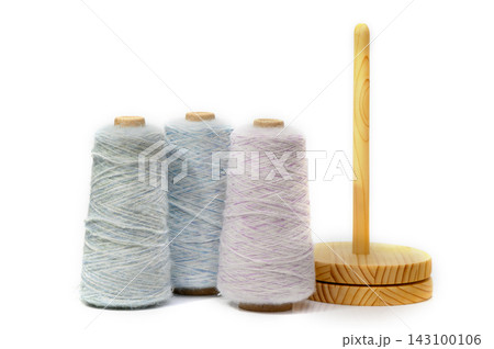 Colorful spools of thread arranged neatly on a wooden stand, inspiring creativity in a cozy craft corner 143100106