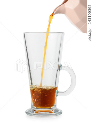Stock photo of coffee pouring from a pitcher into a tall glass mug Stock photo of coffee pouring from a pitcher into a tall glass mug 143100362