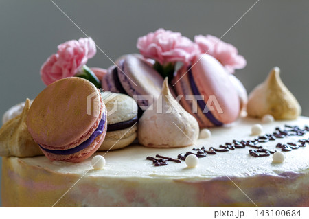 Sweet colorful cake with french macaroons on top Sweet colorful cake with french macaroons on top 143100684