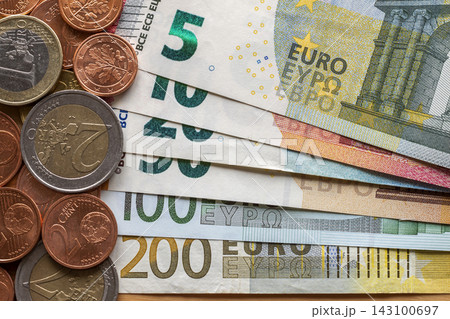 Neatly arranged stack of euro banknotes, currency bills worth ten, twenty, one and two hundred euro and different metal coins. Money, busyness and finances, successful investment concept. Neatly arranged stack of euro banknotes, currency bills worth ten, twenty, one and two hundred euro and different metal coins. Money, busyness and finances, successful investment concept. 143100697