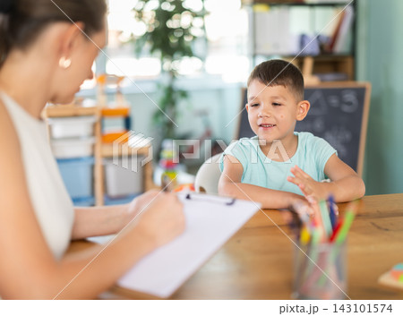 Child psychologist fills out questionnaire and interviews boy in kindergarten. 143101574