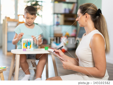 Boy plays with wooden sorter Boy plays with wooden sorter 143101582