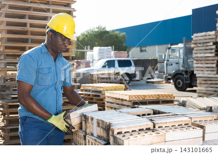 man is checking quality of bricks in the open area of a construction store man is checking quality of bricks in the open area of a construction store 143101665