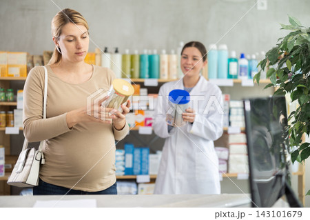 Pregnant woman choosing baby formula with help of pharmacist Pregnant woman choosing baby formula with help of pharmacist 143101679