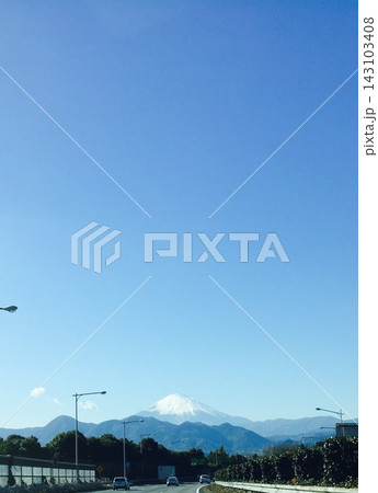 青空の下、高速道路の正面に見える雪化粧の富士山 青空の下、高速道路の正面に見える雪化粧の富士山 143103408