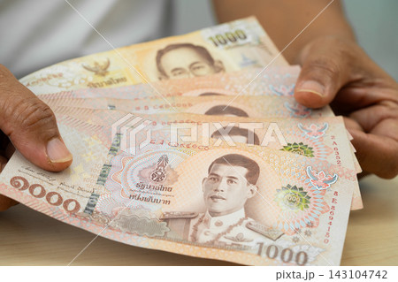 Asian woman holding Thai banknotes money, economy finance exchange trade investment. Asian woman holding Thai banknotes money, economy finance exchange trade investment. 143104742