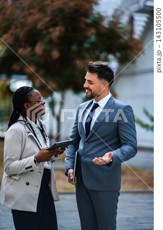 Diverse business professionals having informal meeting outdoors 143105500