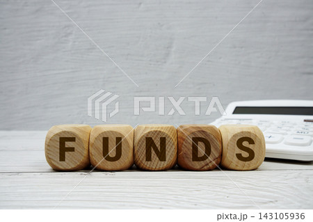 FUNDS alphabet letters with calculator on wooden background 143105936