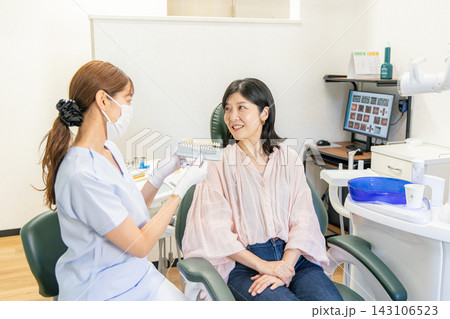 歯医者で歯科衛生士と会話をする女性 歯医者で歯科衛生士と会話をする女性 143106523