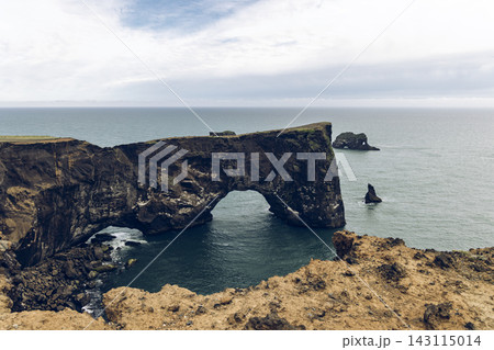 Dyrholaey Arch and volcanic sea cliffs above the Atlantic Ocean in Iceland Dyrholaey Arch and volcanic sea cliffs above the Atlantic Ocean in Iceland 143115014