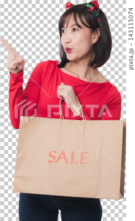Excited young asian woman holding paper bag pointing up during christmas sale and black friday shopping event with cheerful mouth expression against transparency background 143115074