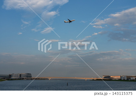羽田の水辺と空港を飛ぶ飛行機 143115375