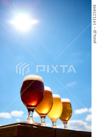 Red amber and golden craft beers in glasses under clear blue sky. Red amber and golden craft beers in glasses under clear blue sky. 143115848