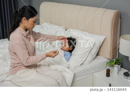 mother using thermometer measuring temperature to checking fever of sick preschoool child girl while hand touching forehead in bed mother using thermometer measuring temperature to checking fever of sick preschoool child girl while hand touching forehead in bed 143116045