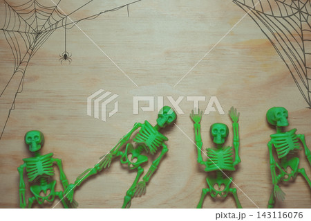 Green Skeleton Toys on Wooden Surface with Spider Webs 143116076