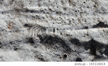 Rough gray concrete texture with dark horizontal streaks and scattered pitted holes Rough gray concrete texture with dark horizontal streaks and scattered pitted holes 143118814