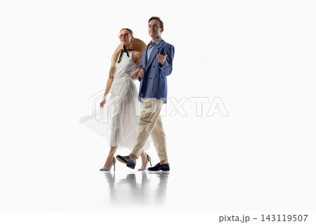 Stylish couple walks together in coordinated light summer outfits 143119507