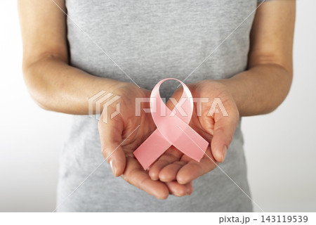 Middle Age Caucasian Woman Holding Pink Ribbon for Breast Cancer Awareness Middle Age Caucasian Woman Holding Pink Ribbon for Breast Cancer Awareness 143119539