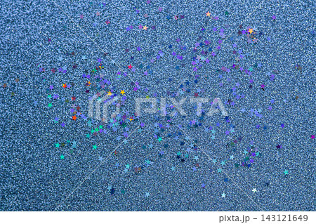 Blue glitter background with scattered holographic star confetti and sparkling texture 143121649