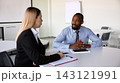 Male executive explains ideas to a businesswoman during airport meeting with serious confidence 143121991