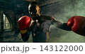 Confident fighter throws a powerful punch through gym smoke with competitive excitement 143122000