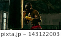 Dedicated fighter practices close-range punches on a heavy bag with relentless energy 143122003