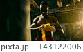 Serious boxer wraps his hands beside a heavy bag with calm preparation 143122006